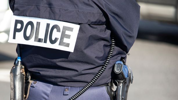 The back of the police officer with the inscription "POLICE" with a gun and a walkie-talkie. Découverte d’un meurtre au Grau-du-Roi : un adolescent avoue