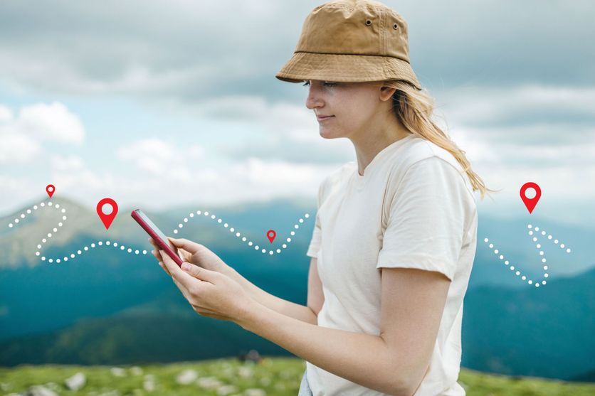 Success tourist woman searching right direction on smartphone on top of mountain with nature background. Mountain progression path. Les applications numériques transforment la randonnée